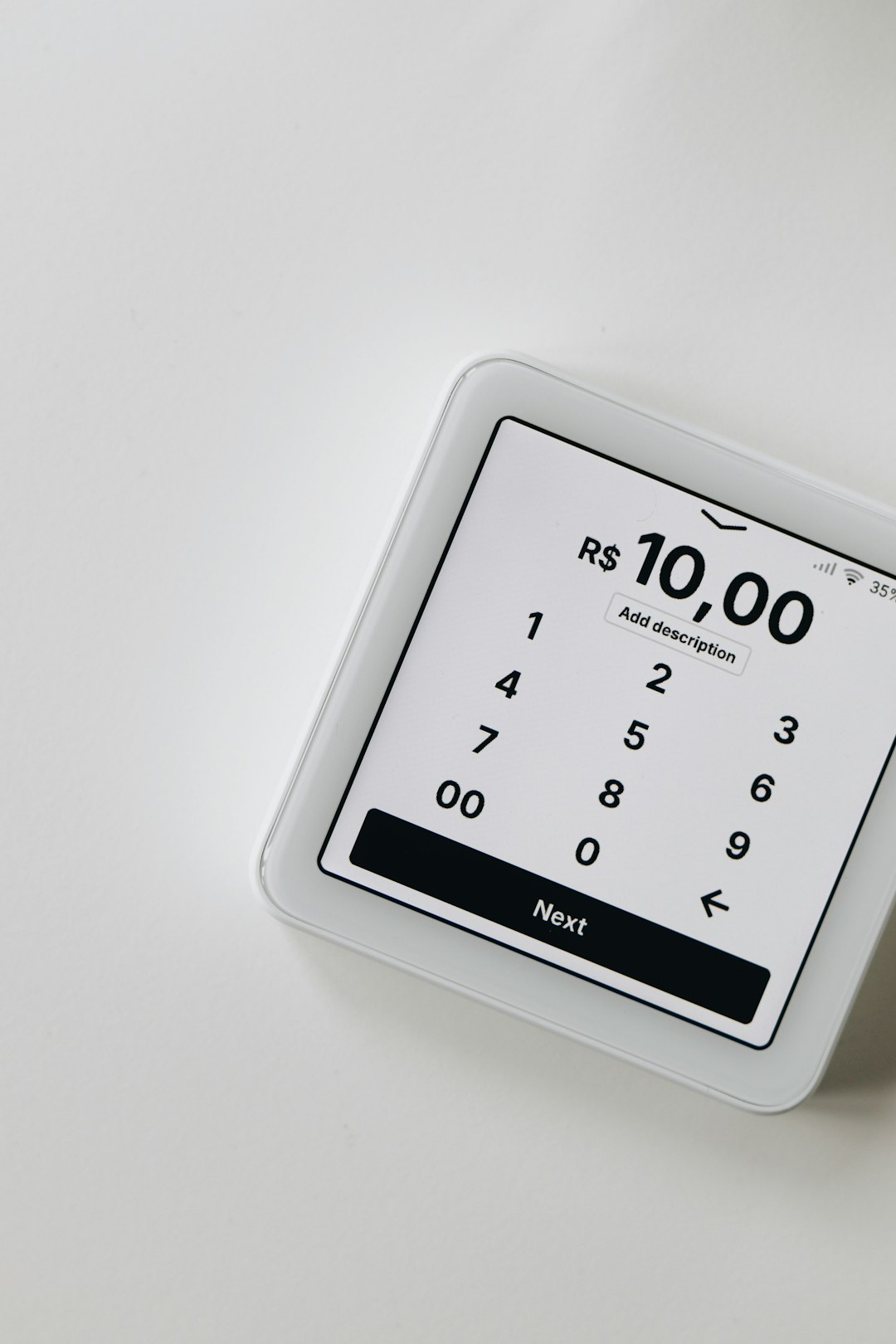 A close-up of a white SumUp card reader displaying a transaction amount of R0,00. The card reader interface is simple and intuitive, with the option to add a description and proceed to the next step.