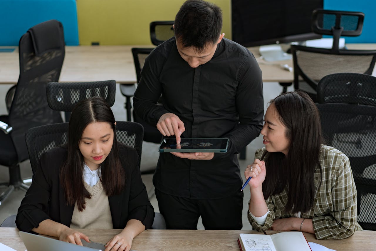 Group of young professionals engaged in a collaborative discussion using digital technology in a modern office.